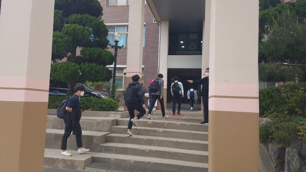 마스크를 낀 학생들이 거리를 유지하며 등교하고 있다.