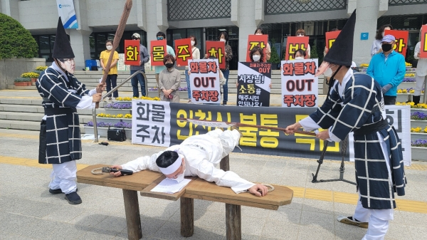 대책위는 12일 인천시청 앞에서 송도 주민들이 매를 맞는 퍼포먼스를 진행했다.
